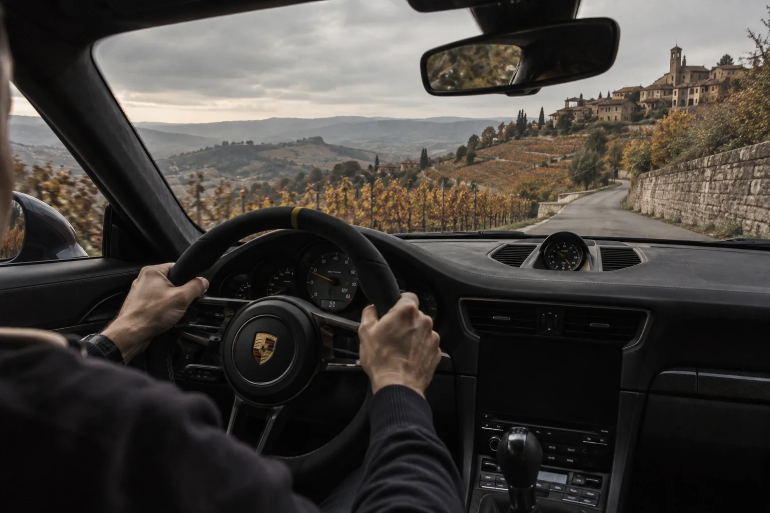 Vista dall’abitacolo di una Porsche lungo una strada delle Langhe, visual illustrativo